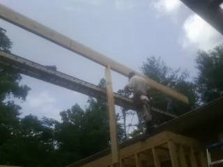 Carpenter setting a ridge beam over a new addition frame — Ice Dam Removal by Roofing Brothers in Shawmut
