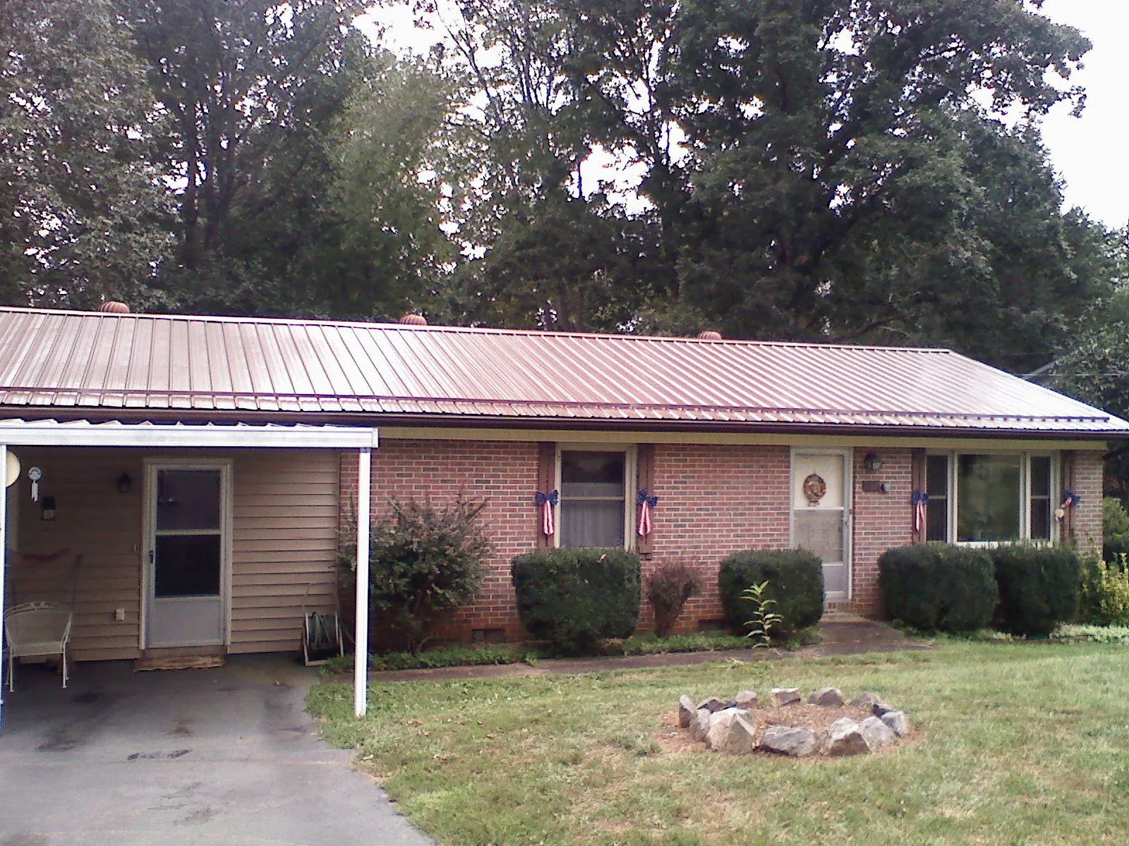 Bronze metal roof and carport on a brick ranch home — Roof Repair work by our crew in Shawmut